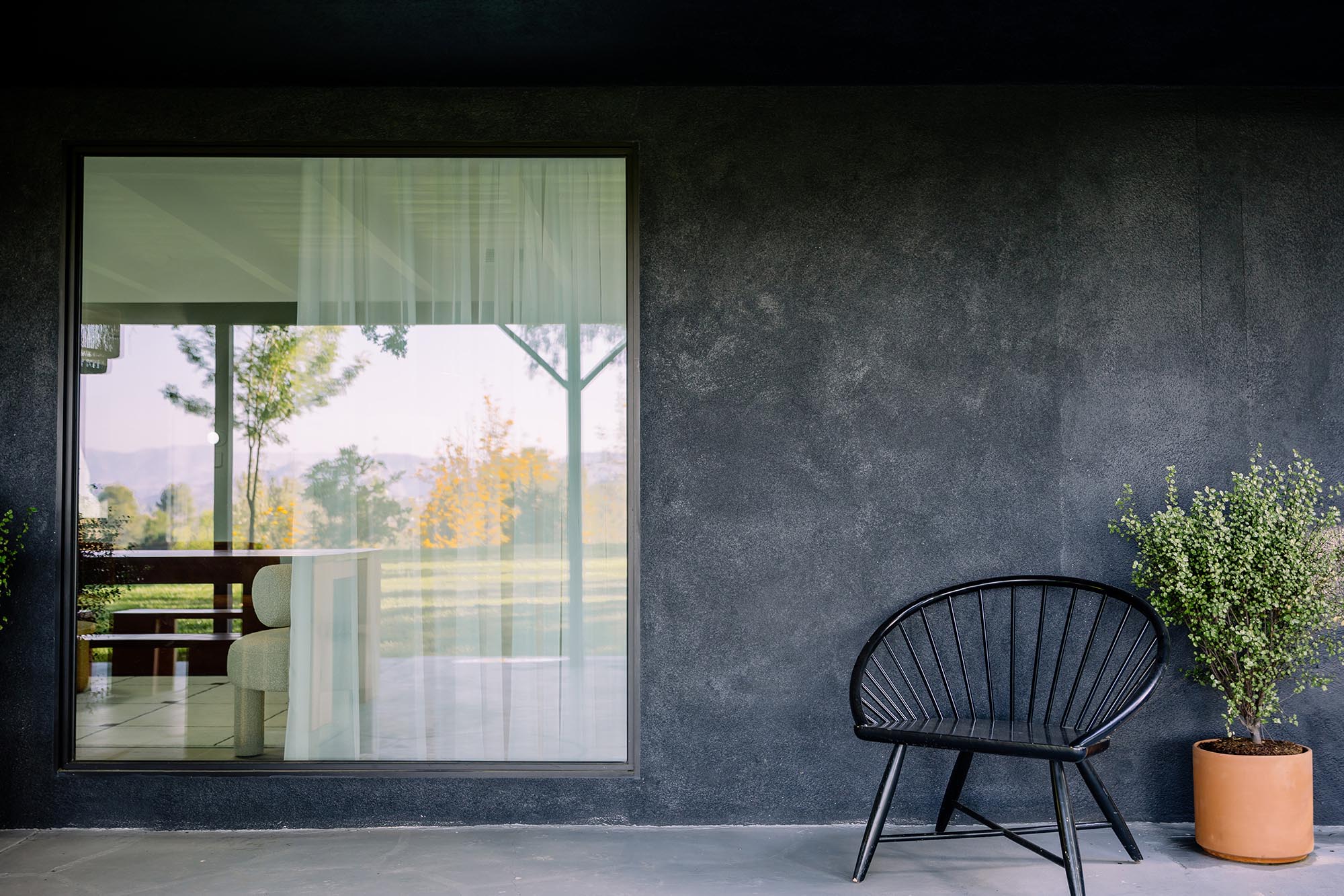 A large fixed window connects this home to the patio and views of the landscape.