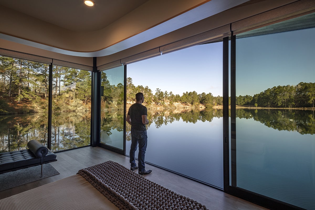 A man stares in a doorway opening directly over the lake.