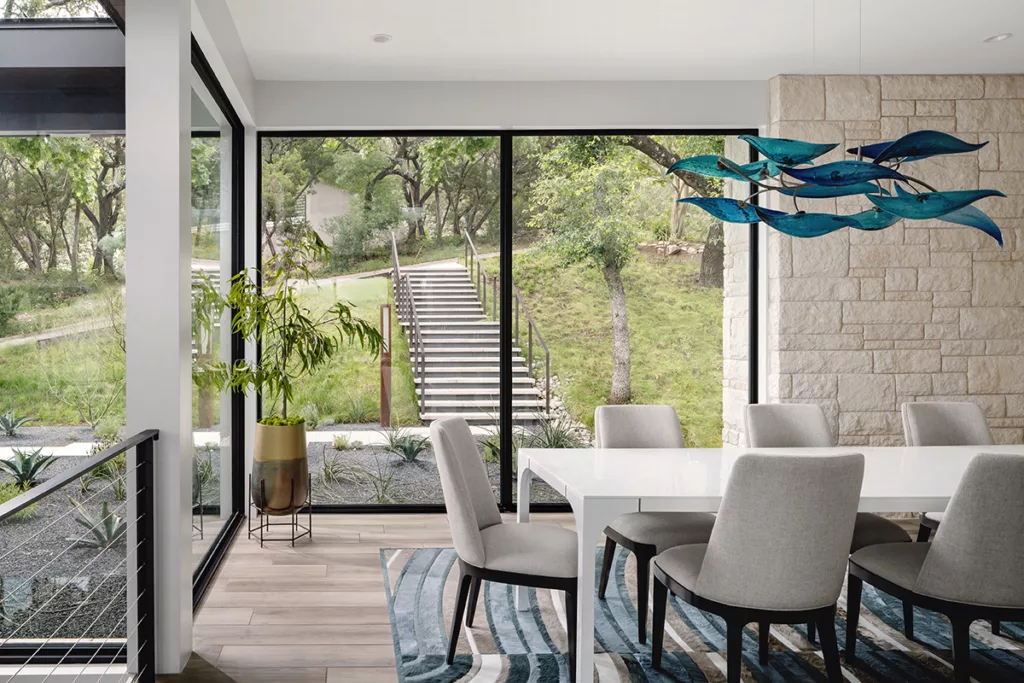 The dining room enjoys views of the front of the home through massive glass panes.