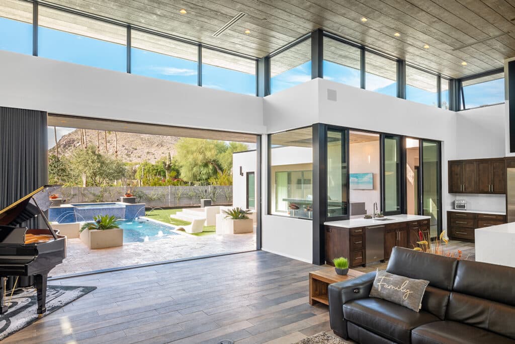 A large, open multi-slide door that opens to a backyard with a pool.