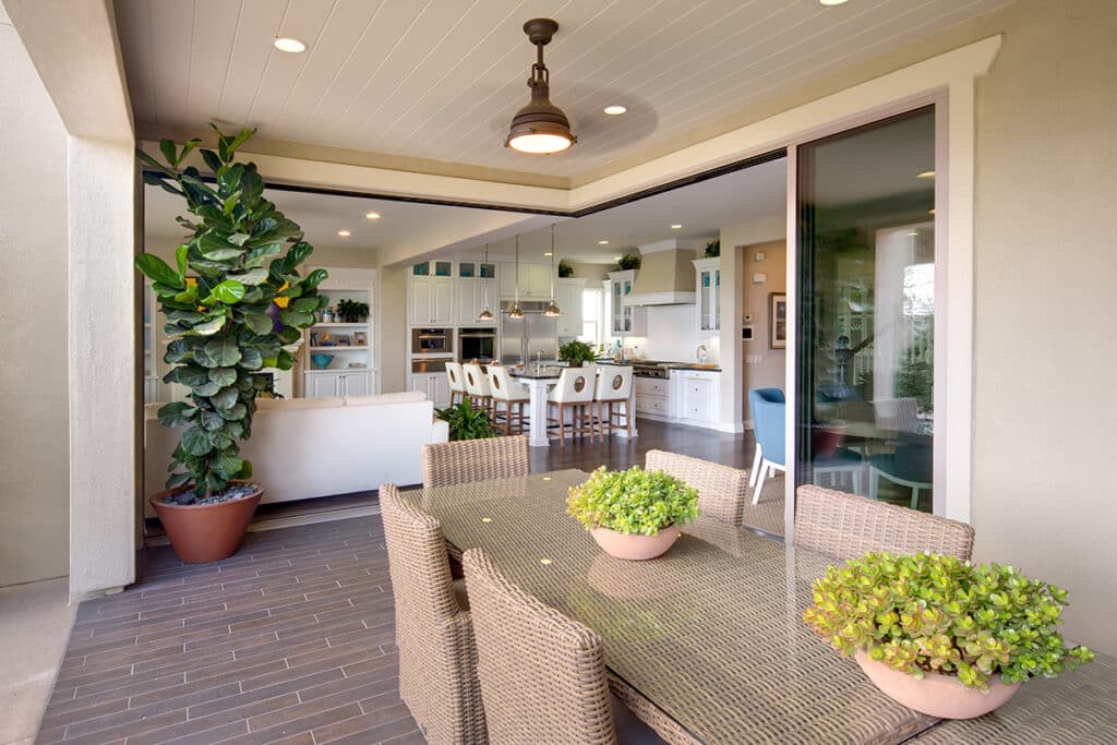 A 90-degree multi-slide door blends an outdoor seating area and an indoor kitchen and dining area together.