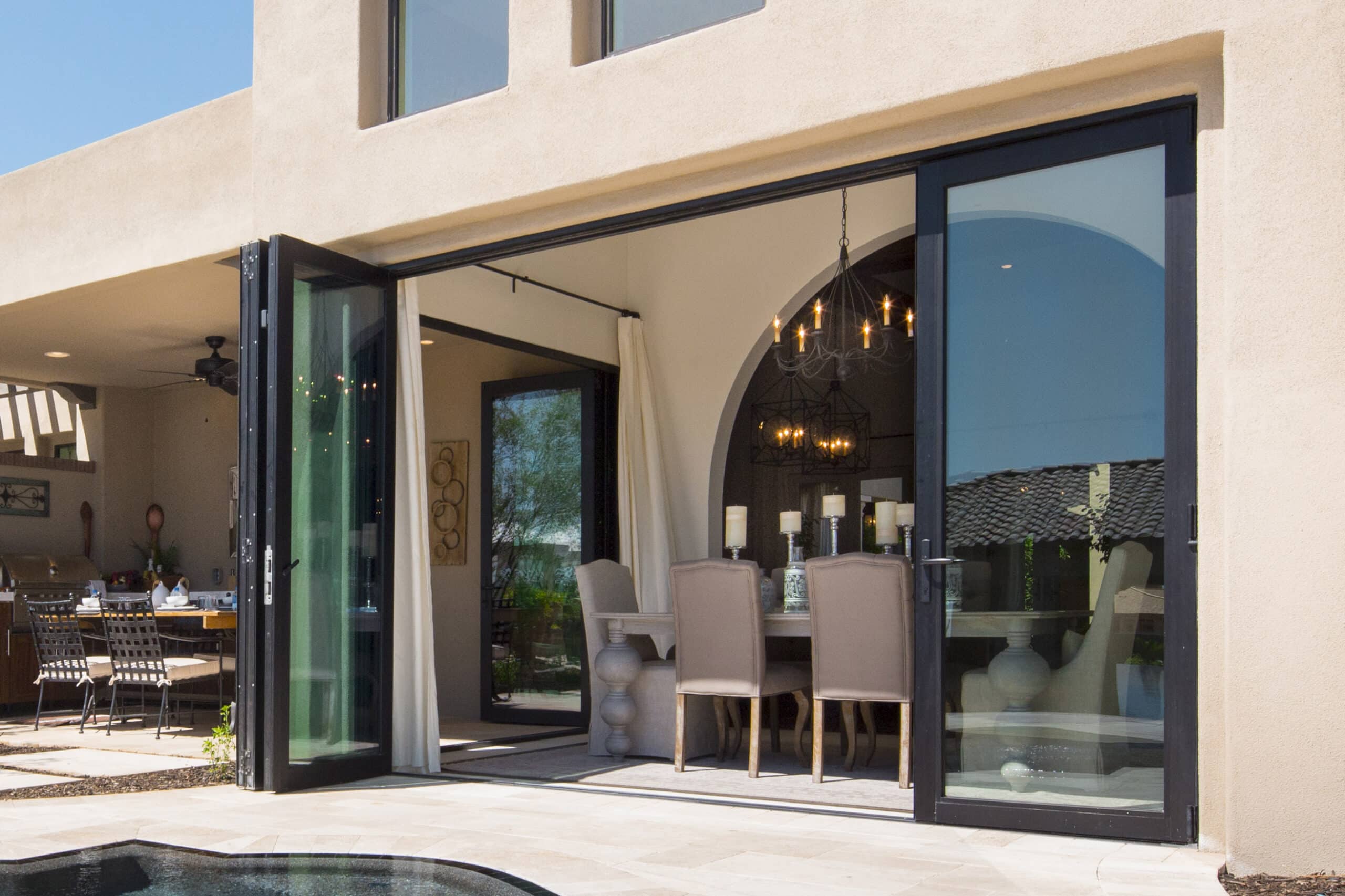 Two open bi-fold doors with a closed egress door connect the dining room to the backyard.