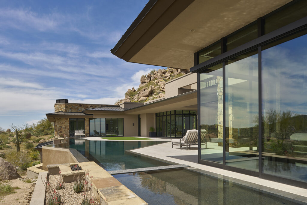 Exterior view of the backyard and sliding glass doors of a custom home.