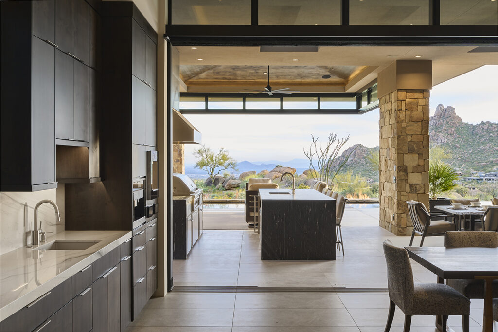 Interior view of a kitchen leading to an outdoor patio with a fully opened Series 600 multi-slide door.
