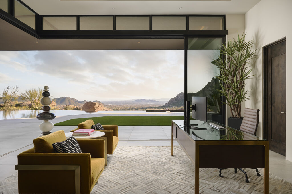 Interior view of an office with opened Series 600 multi-slide doors showcasing sunset views.