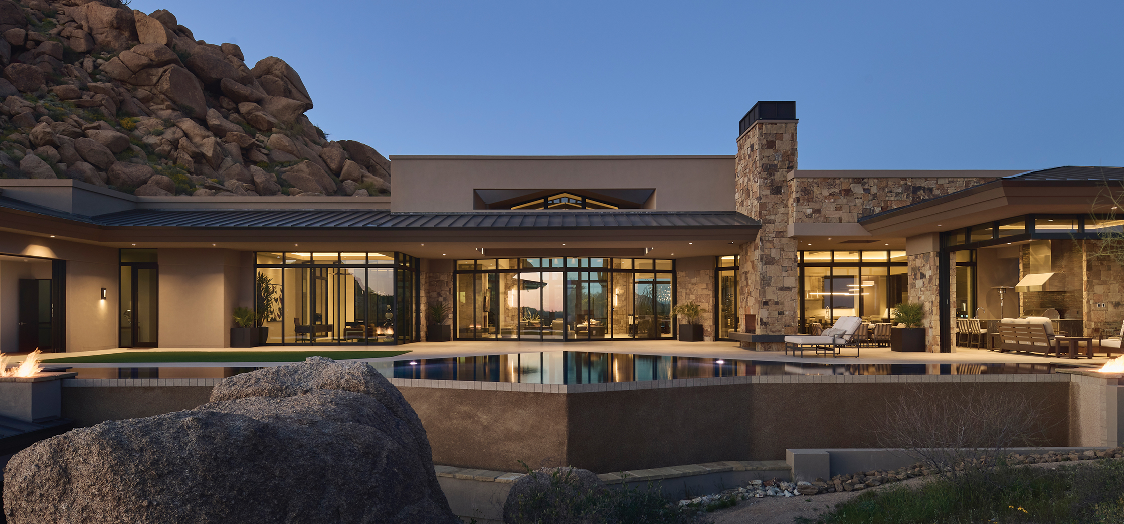 Exterior view of a modern Scottsdale foothills home surrounded by rocky terrain.