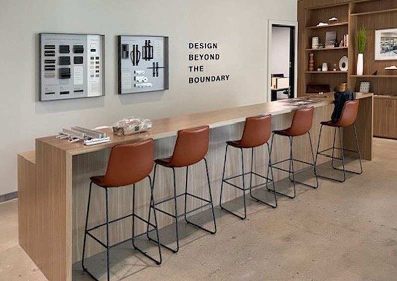 Interior view of the design studio showcasing samples, sample boards, and a large island with several bar stools