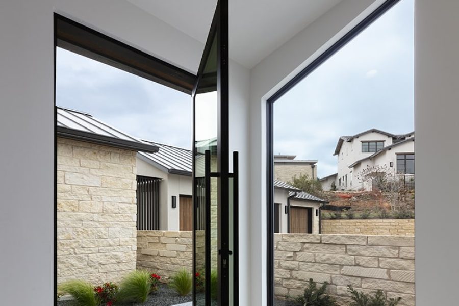 A glass pivot door sits at a 90-degree angle from a fixed window the same size.