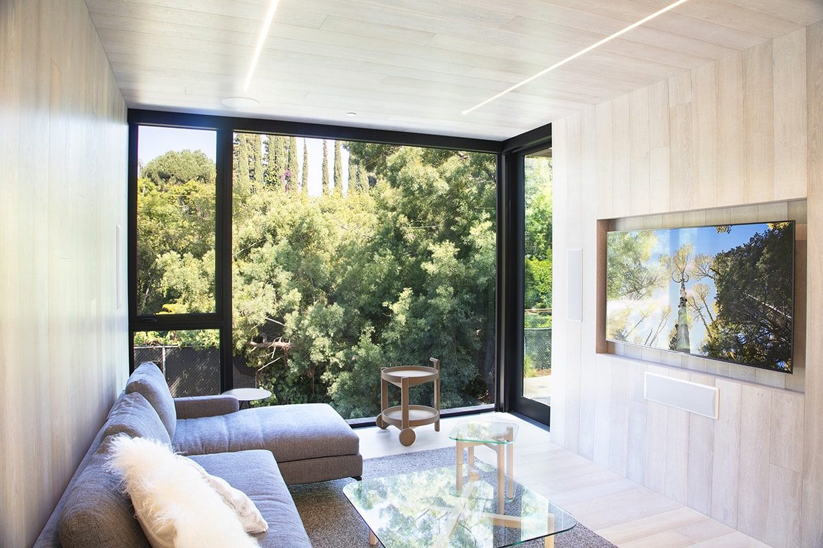 The window wall in this living room is not only floor-to-ceiling, but also stretches the entire width of the wall.