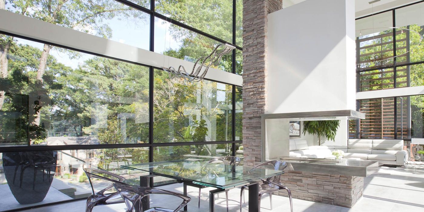 The floor-to-ceiling window wall frames the forestry surrounding this contemporary home.