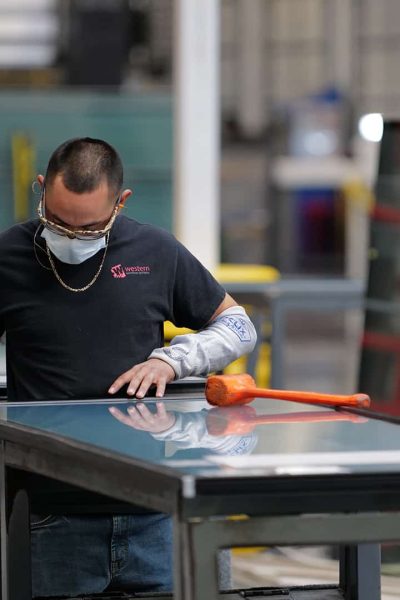 A shop employee works on assembling a panel.