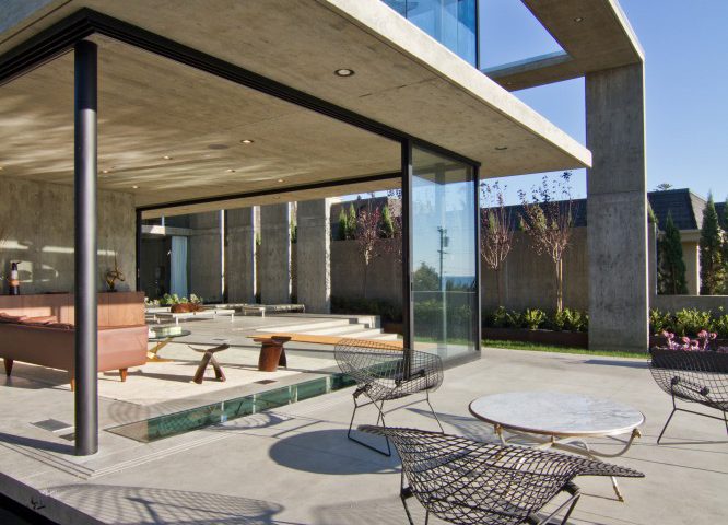 A view of a patio blending into a sun room via an open multi-slide door.