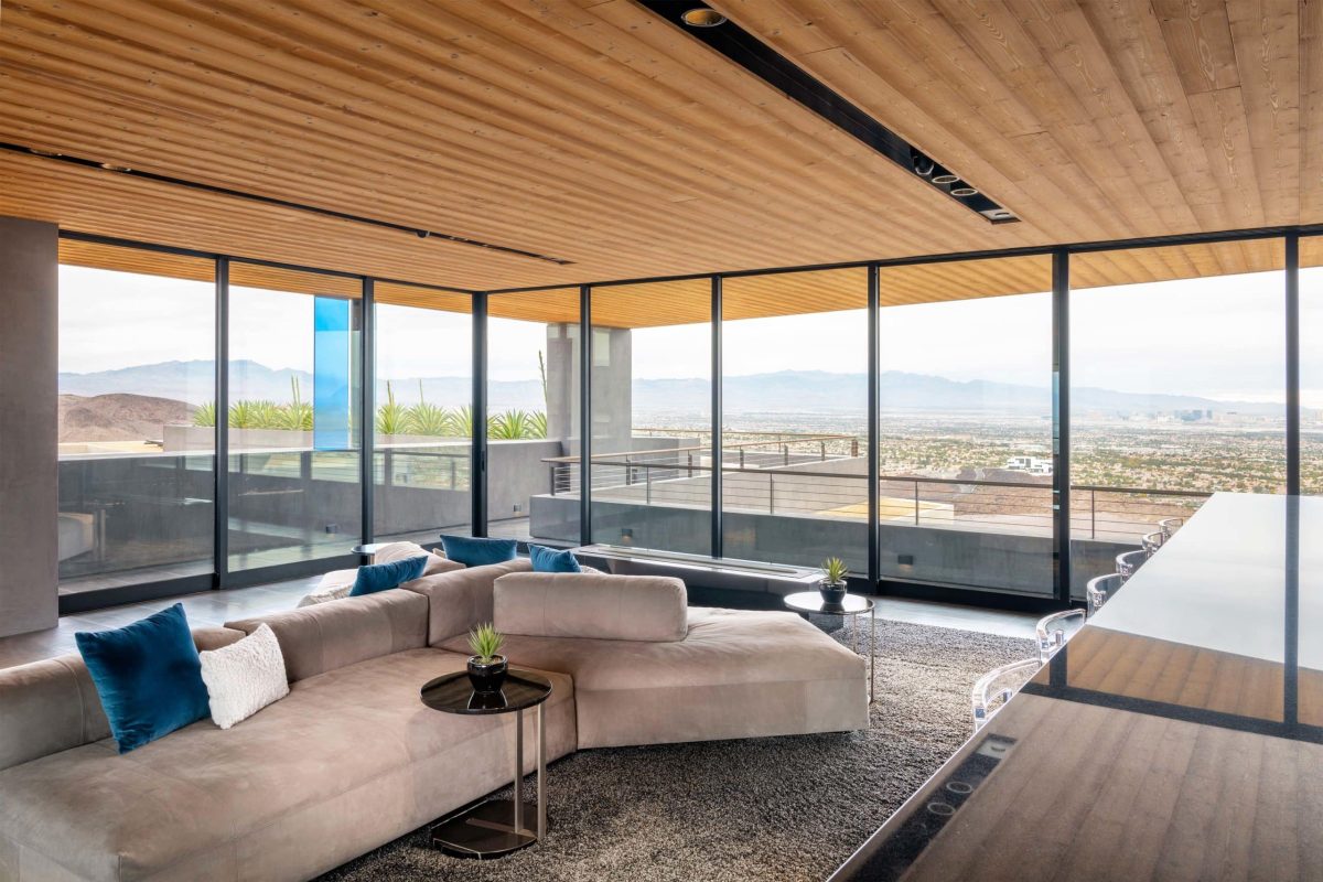 Large multi-slide door panels in a 90-degree configuration enclose the upper floor of a Vegas home, displaying the mountains in the distance.