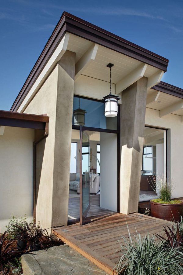 A large, open Series 980 pivot entry door with a transom window makes an inviting entrance to this home on the beach.